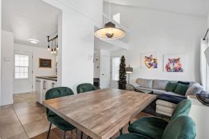 博普雷INITIAL - PETIT BONHEUR - Mont-Sainte-Anne的客厅配有木桌和绿色椅子