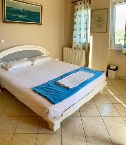 卡特罗斯SAINT GEORGE的一张白色的床,上面有蓝色的毯子