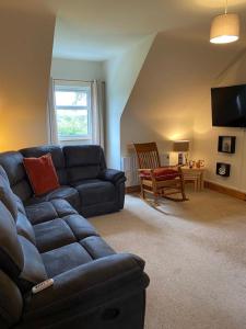 克利夫登Racecourse Lodge Apartment的客厅配有蓝色的沙发和椅子