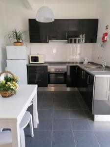 蒙塔吉尔Alojamento Justo - vila de Montargil的厨房配有黑色橱柜和白色桌子