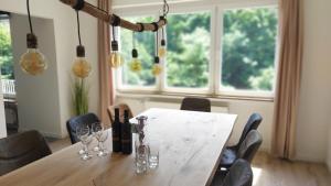 巴特贝特里希Villa Bad Bertrich的餐桌,配有葡萄酒瓶和玻璃杯