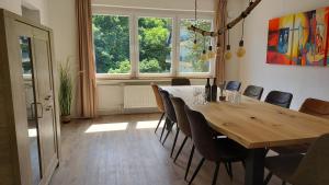 巴特贝特里希Villa Bad Bertrich的一间带木桌和椅子的用餐室