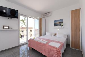 马卡尔斯卡Makarska sea view rooms的一间白色卧室,配有床和电视