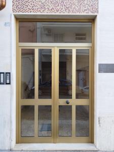 布林迪西Scirocco Guest House的通往带玻璃窗的建筑的门