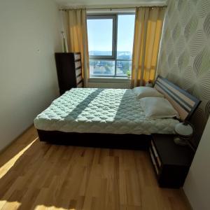 克莱佩达Sunset Terrace Apartment的一间卧室设有一张大床和大窗户