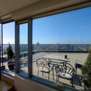 克莱佩达Sunset Terrace Apartment的阳台配有桌椅,享有风景。