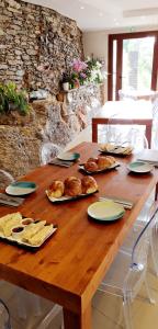 VenzolascaA COSTA的一张木桌,上面有面包和糕点