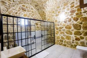 马尔丁KASR-I REYYAN的浴室设有玻璃淋浴间和石墙
