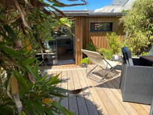 拉蒂尔巴勒Lodge LE CABANON accès direct plage !的一个带椅子的木制甲板和一座房子