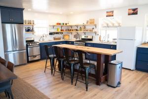 卡纳布BaseCamp 37°的厨房配有蓝色橱柜和木桌及椅子