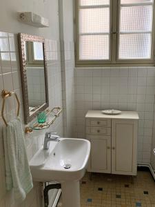 TreignacTreignac Tourelles的白色的浴室设有水槽和镜子