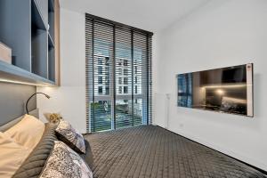 罗兹Luxury Copper Apartment的带沙发和大窗户的客厅