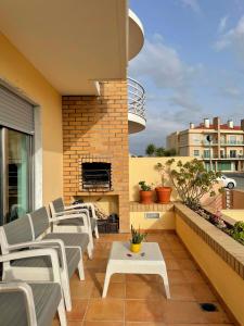 托里什韦德拉什casa da praia azul的阳台设有1个带椅子和壁炉的庭院