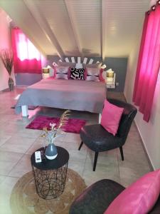 大博格La mélodie des oiseaux的大卧室配有一张带粉红色枕头的大床