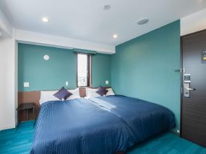 岐阜HOTEL LiVEMAX Gifu Ekimae的蓝色卧室设有一张带蓝色墙壁的大床