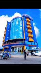 杜阿拉Marriot Metropolitan Hotel的一座蓝色的建筑,前面的人站在