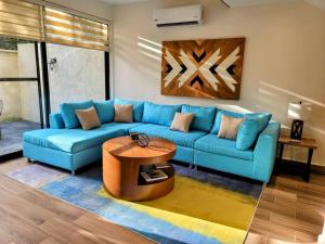 普拉亚卡门Amazing Dream Home in Gated Community的客厅配有蓝色的沙发和桌子