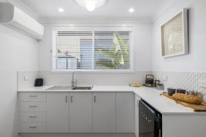萨维特尔Sea Pine Studio的白色的厨房设有水槽和窗户