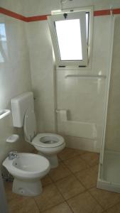 莱乌卡Attico Panoramico的一间带卫生间、窗户和淋浴的浴室
