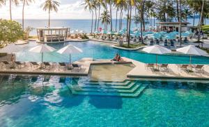 邦涛海滩SAii Laguna Phuket的一个带椅子和遮阳伞的游泳池以及大海