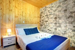 KanakádesTerezina wood house的一间卧室设有一张床和石墙