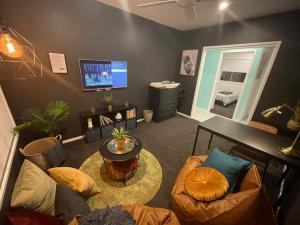 StrathpineTropical Ocean Vibe Holiday House in Strathpine的客厅配有桌椅和电视。