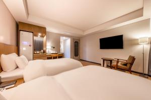光州Hotel the Hill的酒店客房设有两张床和一台平面电视。