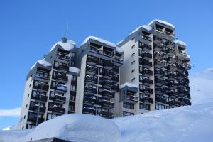 蒂涅Le Schuss Tignes, appartement cosy 4 personnes的两座高大的建筑,前面有雪