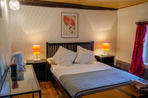 OrdonnacLa Pause Céleste的一间卧室配有一张带两张桌子和两盏灯的床。
