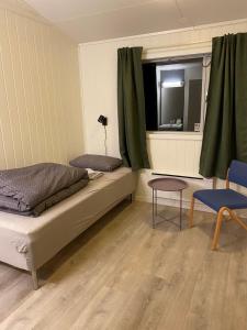 OlsborgHøgtun kulturklynge的一间卧室设有一张床、一个窗口和一把椅子