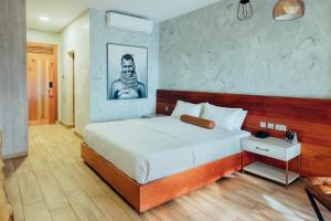 坎帕拉费尔威Spa酒店的卧室配有白色大床和黑白照片