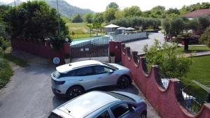 萨尔扎纳Villino Maria的两辆汽车停在围栏旁边的停车场