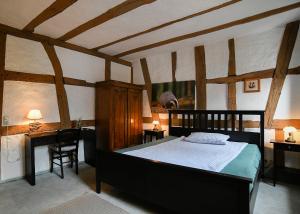 施泰瑙安德斯查瑟Burgmannenhaus的一间带一张大床的卧室,位于一个拥有木制天花板的房间