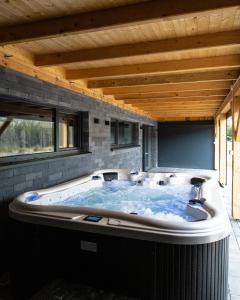 SablówkaJagodówka的一个带木制天花板的房间内的大型热水浴缸