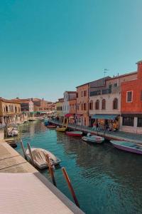 威尼斯Simone Cenedese Murano Apartments - Ambra的运河上的一群船,有建筑物