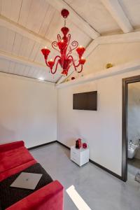 威尼斯Simone Cenedese Murano Apartments - Ambra的一间设有红色床和吊灯的房间