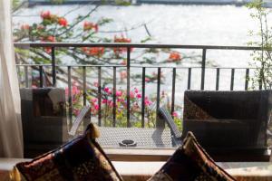 曼谷萨拉阿伦酒店的阳台配有桌椅,享有水景