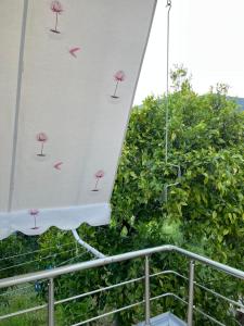 博尔什Cheerful 3-Bedroom Private Villa in Borsh!的阳台上的遮阳伞,上面有粉红色的花朵