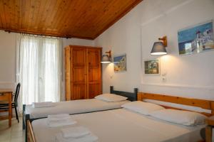 斯科派洛斯Hotel Aggeliki的一间卧室设有两张床和窗户。