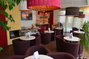 帕兰加Labas Rytas Vila的餐厅设有棕色的桌椅和吊灯