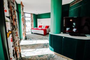 比尔什托纳斯Ego SPA的客厅设有绿色的墙壁和平面电视。