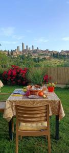 圣吉米纳诺B&B Il Fienile San Gimignano的一张桌子,上面放着食物,享有城市美景