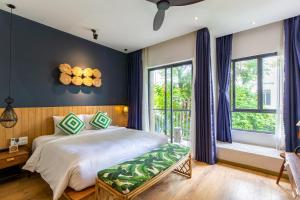 岘港Seaforest Hotel by Haviland的一间卧室设有一张大床,拥有蓝色的墙壁和窗户。