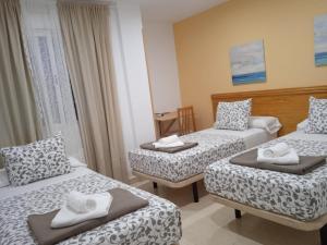 El ÁlamoH El ALAMO MADRID的酒店客房设有两张床和一张桌子。