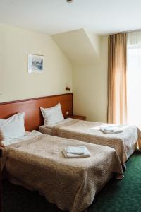 瓦尔纳迪奥尼斯酒店的两张位于酒店客房的床,配有毛巾