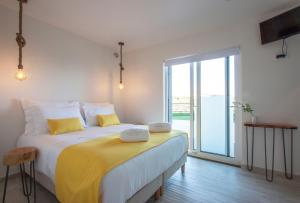 福斯·杜·阿勒奥Hillside House Suites & Spa的一间卧室配有一张带黄色枕头的大床