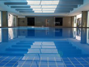 科维良Hotel Covilhã Dona Maria Affiliated by Meliá的一个带蓝色瓷砖地板的游泳池