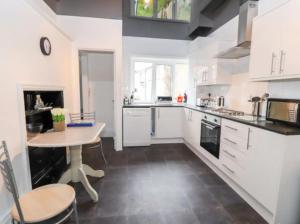 Llandrillo-yn-RhôsSeabreeze Apartment的厨房配有白色橱柜和桌子