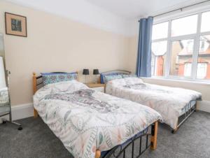 Llandrillo-yn-RhôsSeabreeze Apartment的一间卧室设有两张床和窗户。