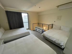 台中市想想逢甲 Shine Residence的酒店客房设有两张床和窗户。